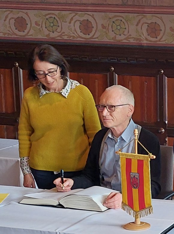 Bild: privat Gerry Hahlo trägt sich ins goldende Buch der Stadt Oldenburg ein.