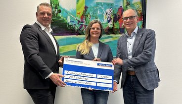 Herrmann Kruse überreicht dem VHS-Geschäftsführer Andreas Gögel und Bildungsmanagerin Anita Groth einen symbolischen Scheck. Bild: VHS Oldenburg