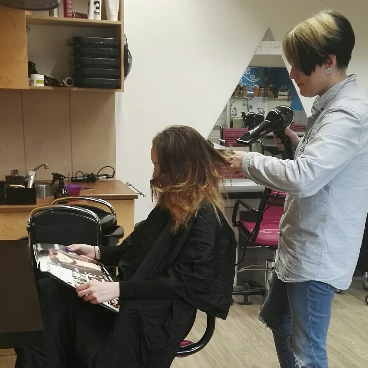 Janine schneidet im Salon der Jugendwerkstatt LUPO einer Teilnehmerin die Haare.