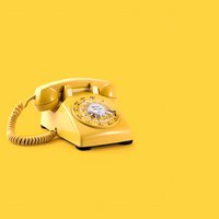 Ein gelbes Telefon mit Wählscheibe