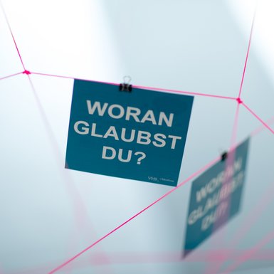 Eine der Karten von „Woran glaubst du?“ in der Fadenausstellung. Bild: CEWE.