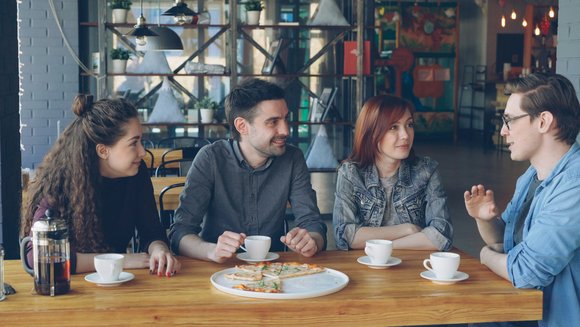 Vier Menschen unterhalten sich in einem Café